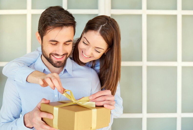 девушка дарит подарок мужу